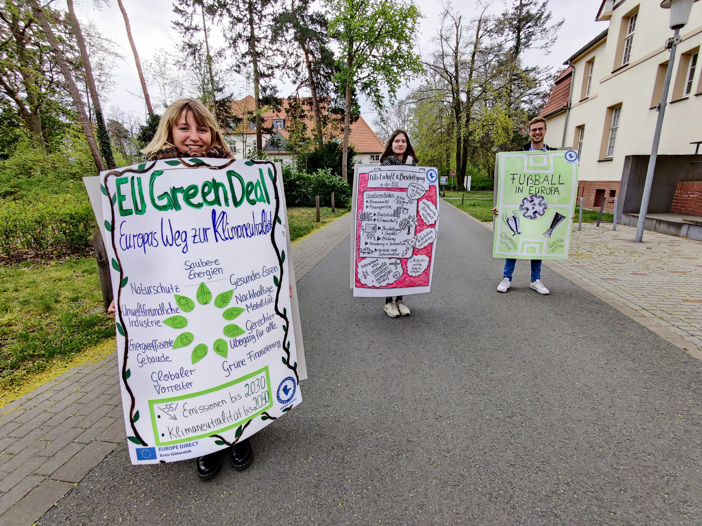 3 Menschen mit Plakaten