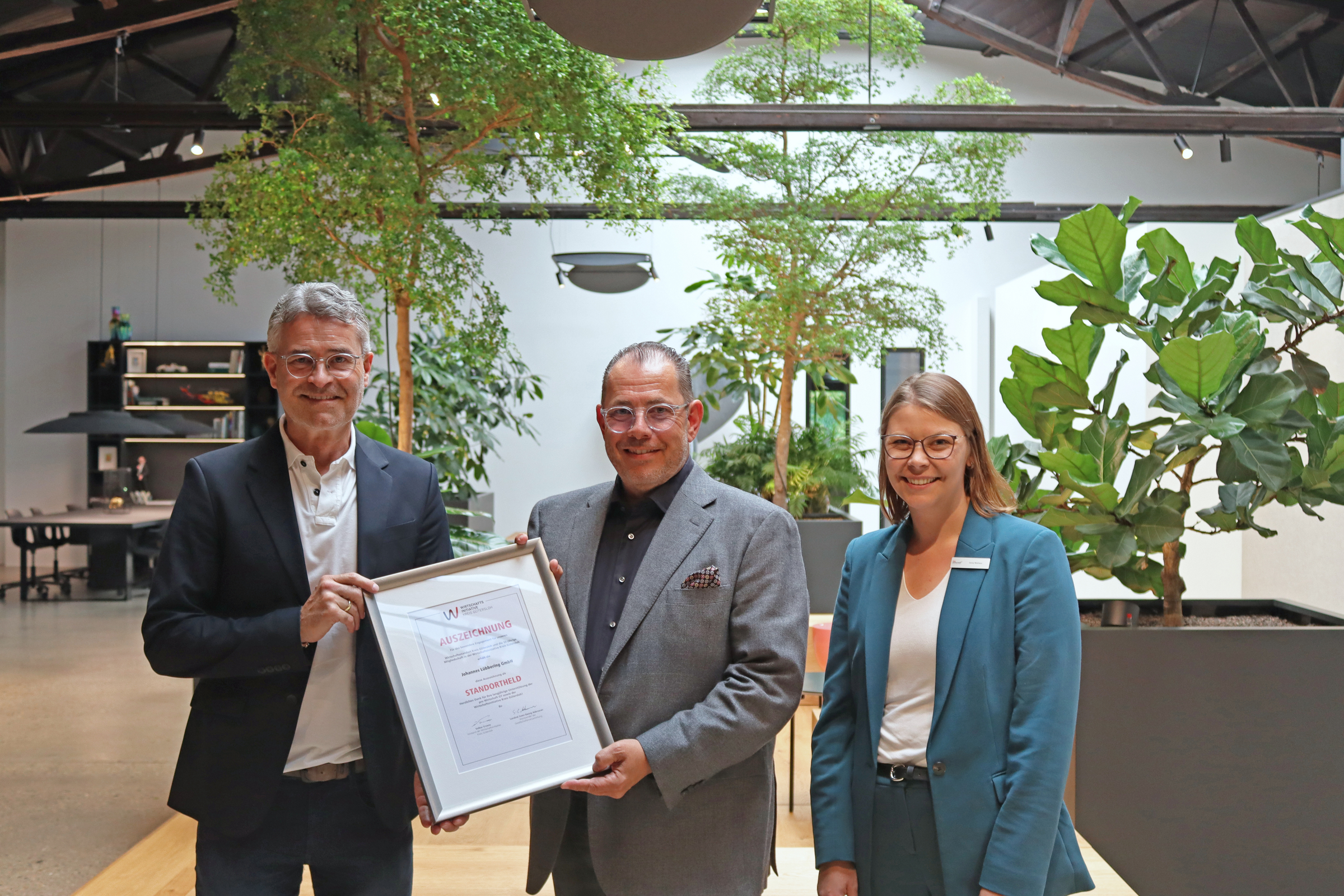 Volker Ervens (links) und Anna Niehaus zeichneten Achim Lübbering und die Johannes Lübbering GmbH als Standorthelden im Kreis Gütersloh aus.