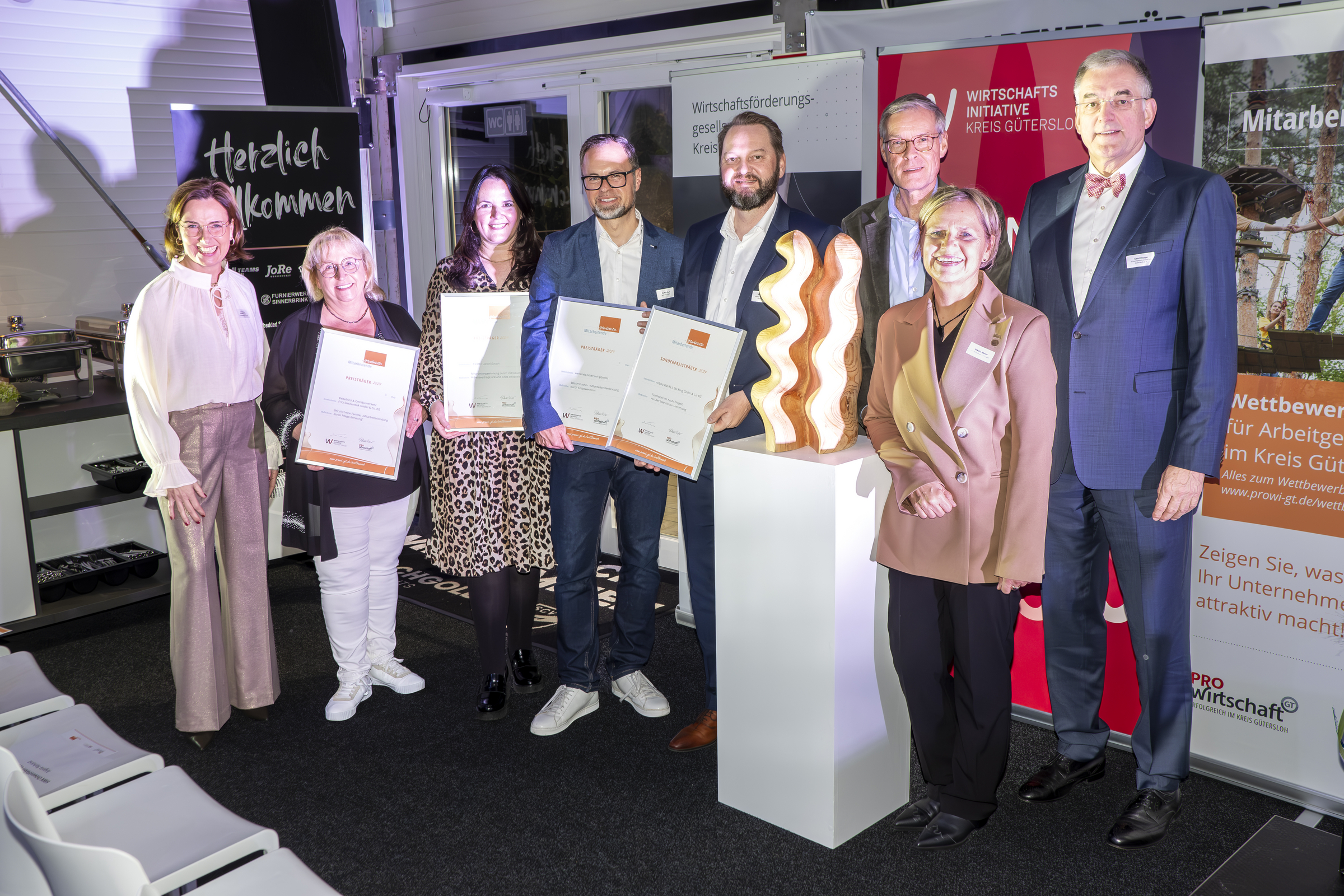 Akteure und Preisträger im Wettbewerb Mitarbeitende.gewinnen (v.l.): Dr. Marita Reinkemeier (pro Wirtschaft GT), Birgit Siekendiek-Rinker (Fritz Siekendiek GmbH), Letta Siebert-Daniel (Elektro Daniel GmbH), Steffen Gerz (Wertkreis Gütersloh), Willy Banmann (nobilia), Landrat Sven-Georg Adenauer, Nikola Weber (pro Wirtschaft GT), Gerd Hoppe (Wirtschaftsinitiative Kreis Gütersloh).